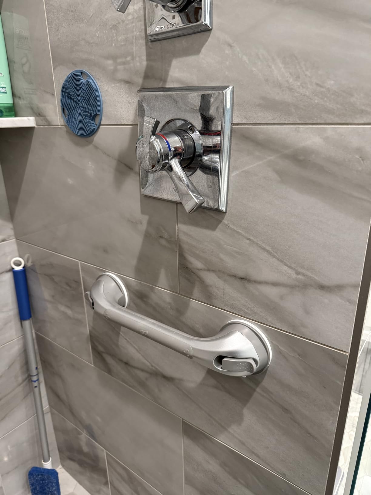 Grab bar mounted on gray bathroom tile