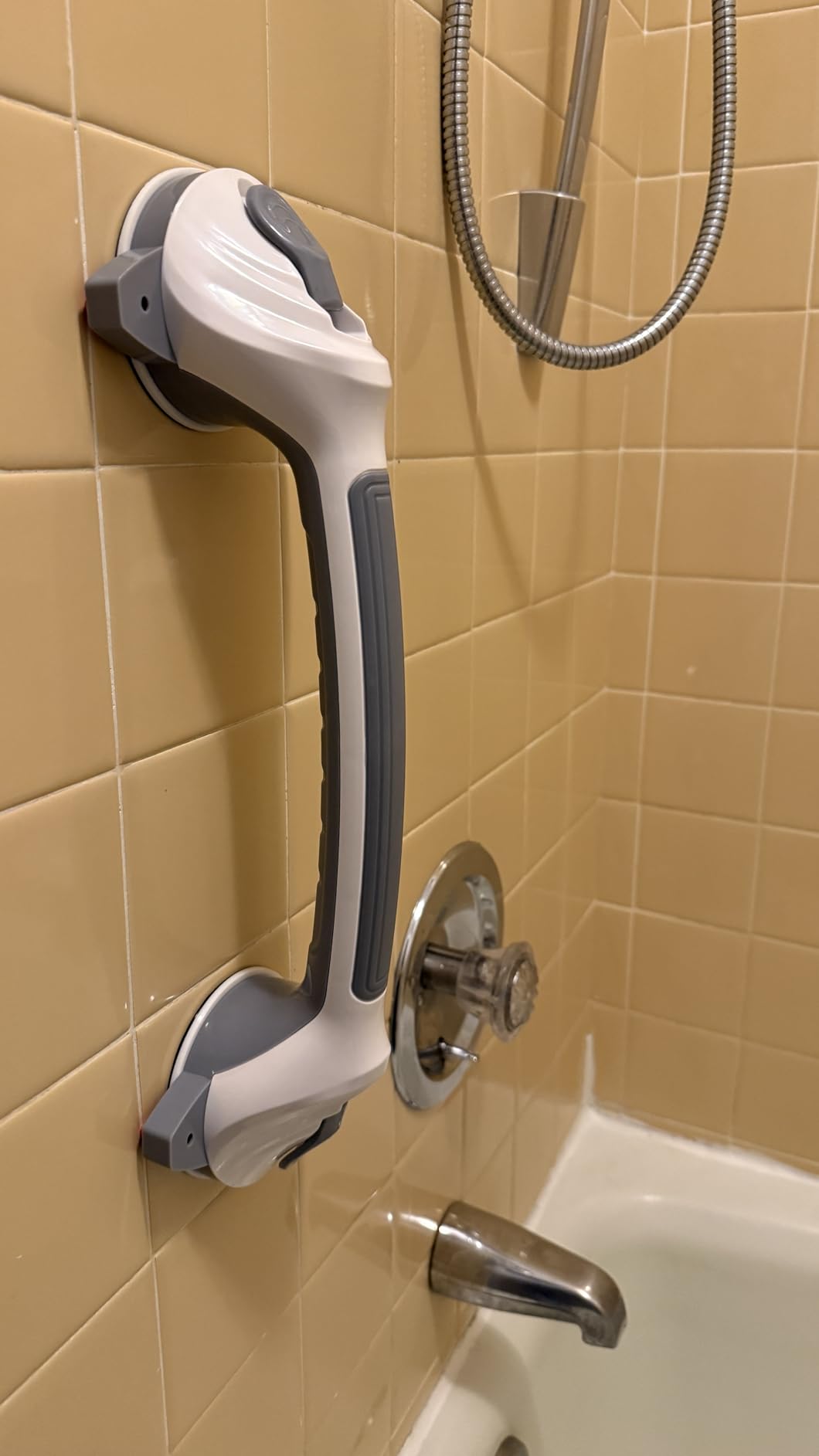 Grab bar attached to yellow bathroom tile