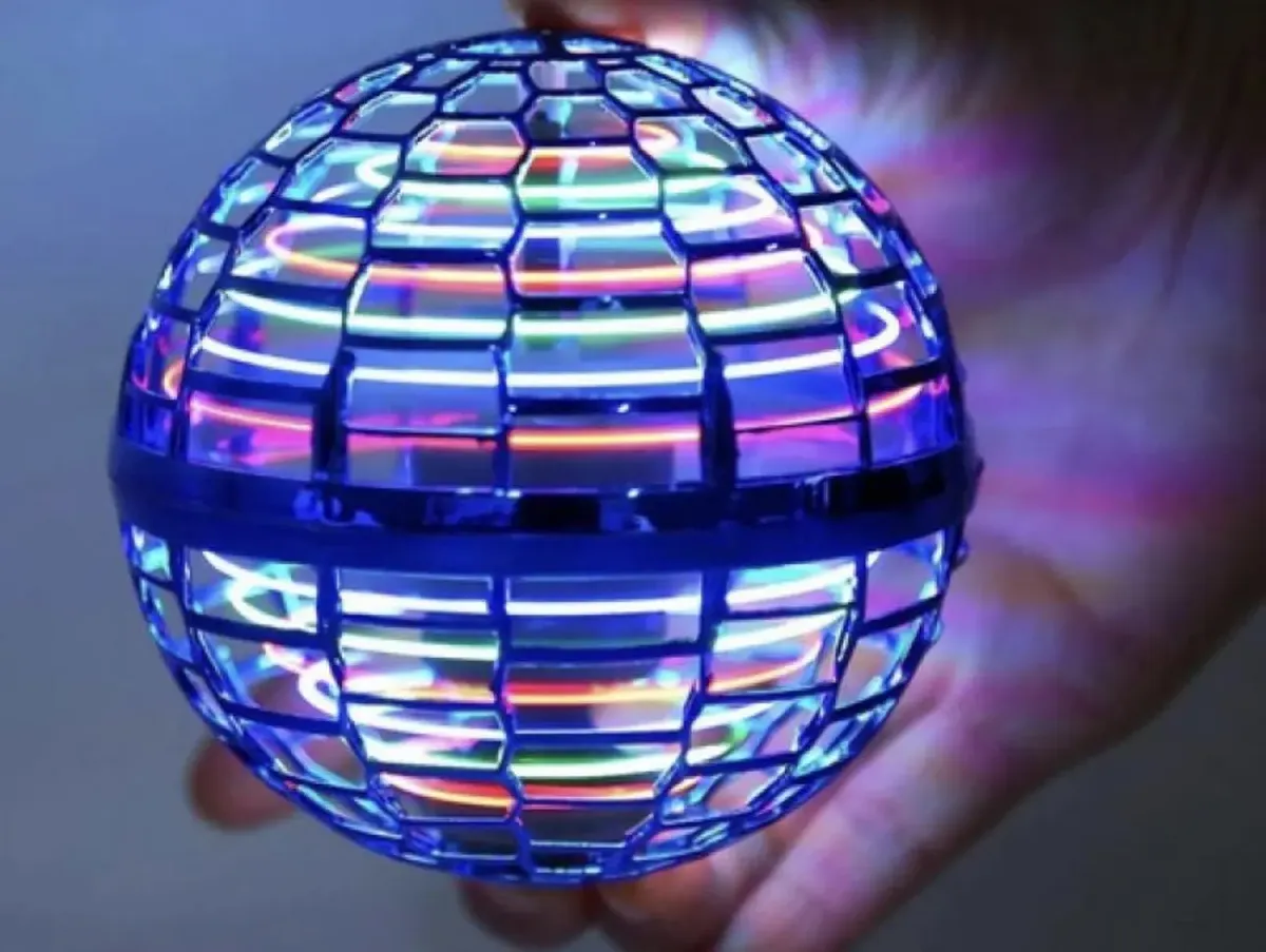 Pelota voladora con luces encendidas sostenida en una mano