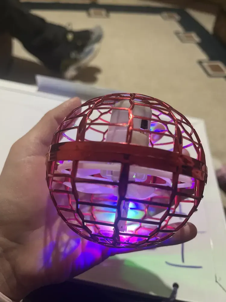 Pelota voladora roja encendida sostenida por un comprador